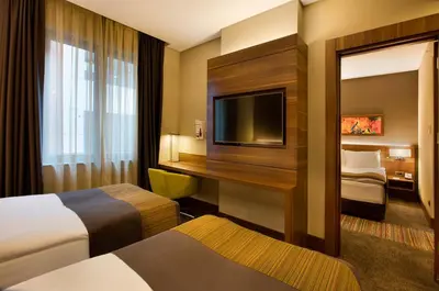 a hotel room with two beds and a flat screen tv at Holiday Inn Istanbul - Kadikoy by IHG in Istanbul