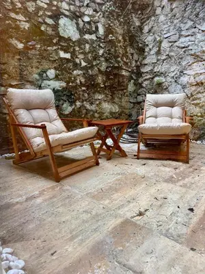 two chairs sitting next to a table in front of a wall at Historic Design 3-Storey Arnavutköy Home with Patio in Istanbul