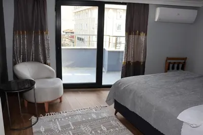 a bedroom with a bed and a chair and a window at DT Suites in Istanbul