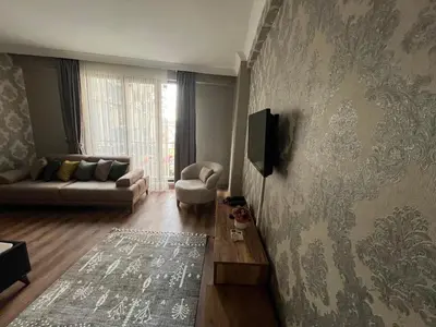 a living room with a couch and a tv on a wall at DT Suites in Istanbul