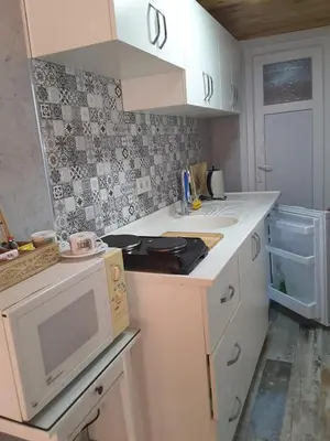 a kitchen with white cabinets and a microwave at La Casa25 in Istanbul
