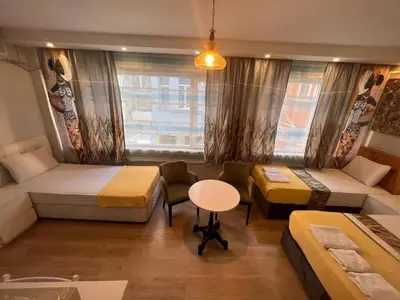 a room with two beds and a table and a window at The Rodin Taksim in Istanbul
