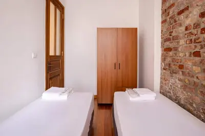 two beds in a room with a brick wall at Charming 2BD2Bath Galata Tower Unique Home! #409 in Istanbul