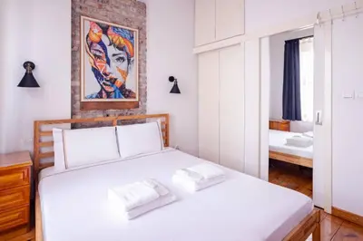 a bedroom with a white bed and a painting on the wall at Authentic Galata Tower Central 2BD2Bath Home #411 in Istanbul