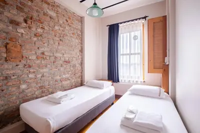 two beds in a room with a brick wall at Galata Tower 2BD2Bath Authentic Gem! #412 in Istanbul