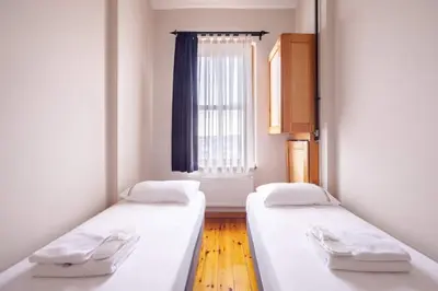 two beds in a room with a window at Cool Authentic 2BD2Bath Galata Tower Home! #413 in Istanbul