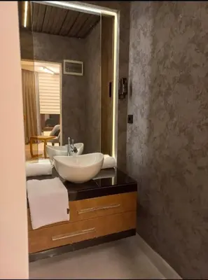 a bathroom with a sink and a large mirror at SARIKÖŞK HOTEL Kadıköy in Istanbul