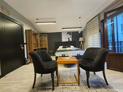 a bedroom with a bed and two chairs and a table at SARIKÖŞK HOTEL Kadıköy in Istanbul