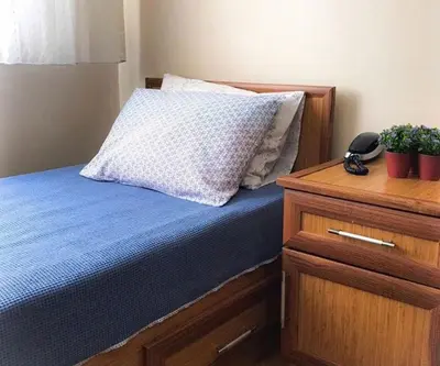 a bedroom with a bed with a pillow and a dresser at Akademik Pansiyon in Istanbul