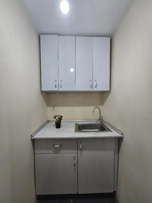 a kitchen with a sink and white cabinets at Taksim Nova House hotel in Istanbul