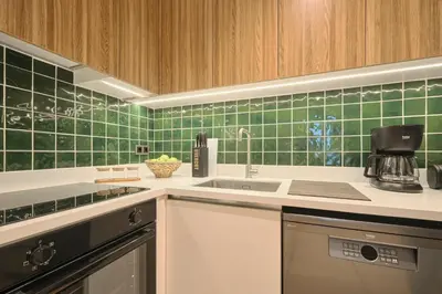 a kitchen with green tiles on the wall at BSY Flats Well Decorated Modern Apartments With 2BR, 3BR Options in Istanbul