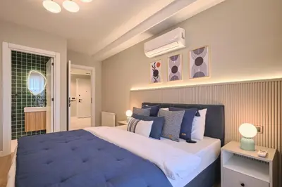 a bedroom with a large bed with a blue blanket at BSY Flats Well Decorated Modern Apartments With 2BR, 3BR Options in Istanbul