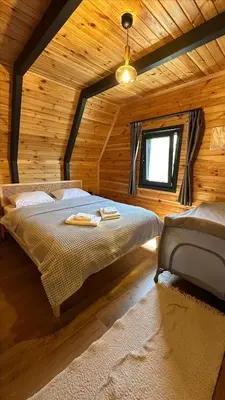 a bedroom with a bed in a wooden cabin at Melodi Bungalov Sapanca in Sakarya