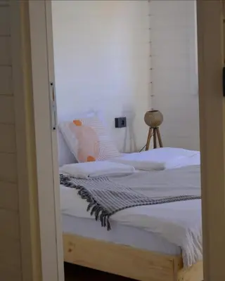 a bedroom with a bed with white sheets at Sapanca Balkaya Bungalov in Sapanca