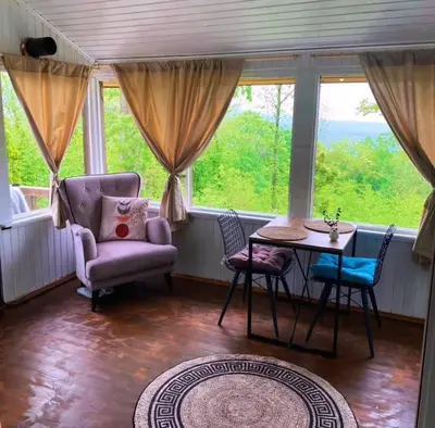 a living room with a table and chairs and a window at Sapanca Balkaya Bungalov Dağ evi in Sapanca
