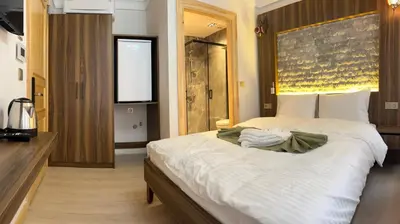 a bedroom with a large bed with white sheets at Arkeon Bosphorus Hotel & Suites in Istanbul