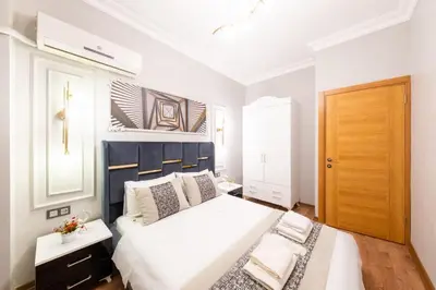 a bedroom with a large white bed with a blue headboard at King Suit Beşiktaş apart in Istanbul
