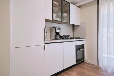 a kitchen with white cabinets and a stove at BSY's Stylish 1BR,2BR ,3BR Apartments in Brand New Building in Istanbul