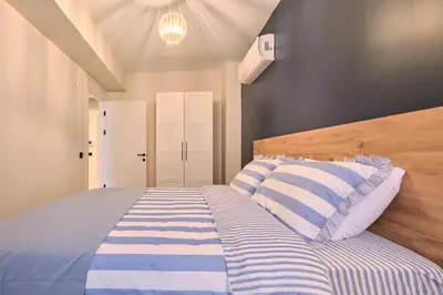 a bedroom with a bed with blue and white stripes at BSY's Stylish 1BR,2BR ,3BR Apartments in Brand New Building in Istanbul