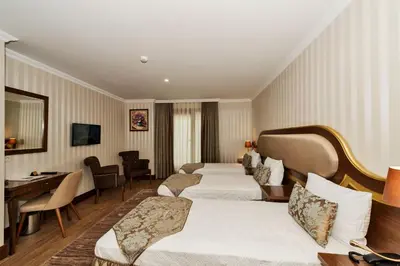 a hotel room with two beds and a desk at The Central Hotel in Istanbul