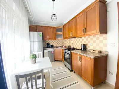 a kitchen with wooden cabinets and a white table at Excelent Location & Spacious No3 in Istanbul