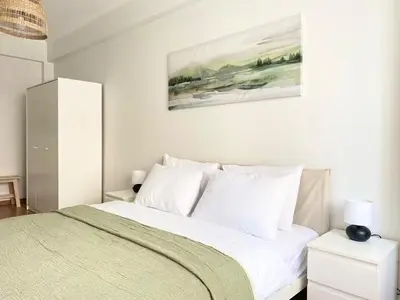 a bedroom with a white bed and a painting on the wall at Excelent Location & Spacious No3 in Istanbul