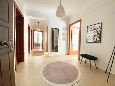 a hallway with a rug and a chair and a door at Excelent Location & Spacious No3 in Istanbul