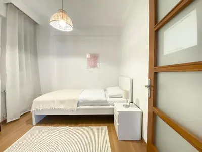 a white bedroom with a bed and a window at Excelent Location & Spacious No3 in Istanbul