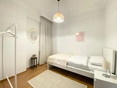 a white bedroom with a bed and a mirror at Excelent Location & Spacious No3 in Istanbul