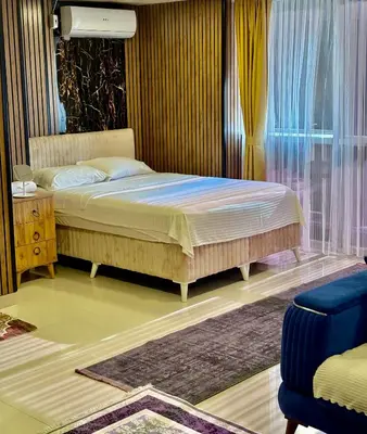 a bedroom with a bed and a chair and a window at Nera Otel in Istanbul