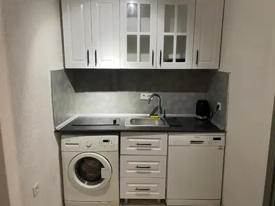 a kitchen with a sink and a washing machine at ŞAH apartmanı in Istanbul
