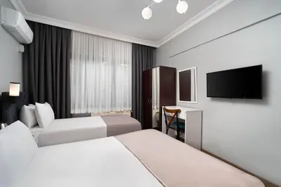 a hotel room with two beds and a flat screen tv at Galey Pört in Istanbul