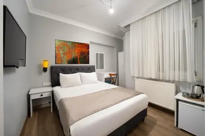 a bedroom with a large white bed and a window at Galey Pört in Istanbul