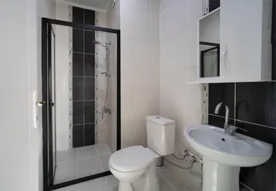 a white bathroom with a toilet and a sink at Galey Pört in Istanbul