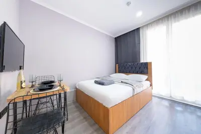 a bedroom with a bed and a desk with a television at Lomend Hotels in Istanbul