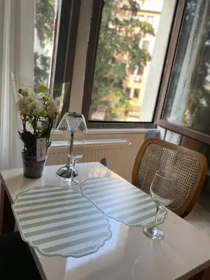 a table with two wine glasses and a vase with flowers at Şah in Istanbul