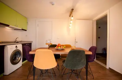 a kitchen with a table with chairs and a bowl of fruit at Blue Mosq Pansiyon & Apart in Istanbul