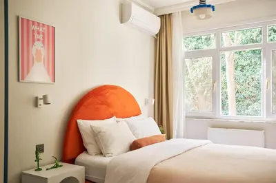 a bedroom with a bed with an orange headboard and a window at Cihangir Pop Art Hideaway in Istanbul