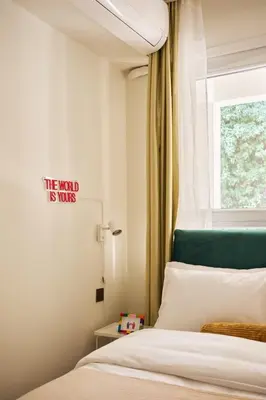 a bedroom with a bed with a green headboard and a window at Cihangir Pop Art Hideaway in Istanbul