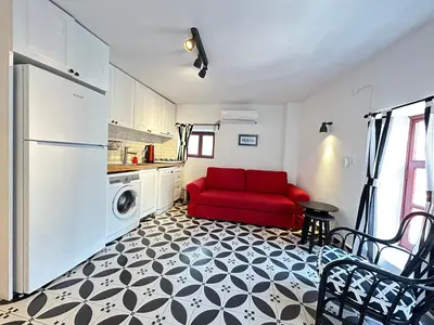 a living room with a red couch in a kitchen at Nefes Ada Taş Bina - Bahçe Katı in Istanbul
