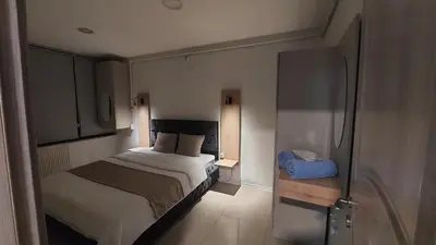 a small bedroom with a bed and a refrigerator at Suiton6 apart otel in İhsaniye