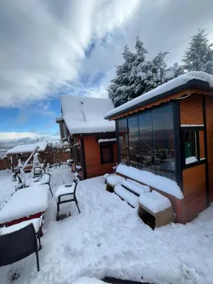 a house covered in snow next to a building at Sapanca Turuncu Hobbit Evi in Sapanca