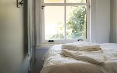 a bed with two white towels on it in front of a window at Hill House Hostel in Istanbul