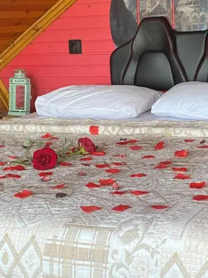a bed with flowers on it with a red wall at Sapanca Kırmızı Hobbit Evi in Sapanca