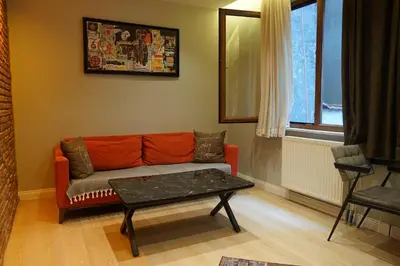 a living room with an orange couch and a table at The İstanbul Levent Çakra Palace in Istanbul