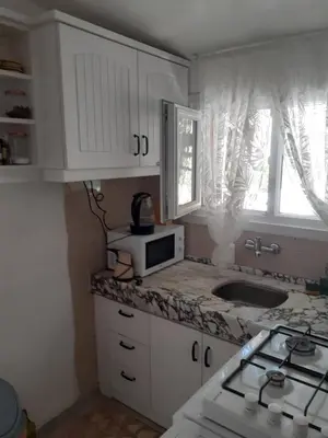 a kitchen with white cabinets and a sink and a microwave at Art & Natura in Marmara