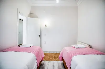 two beds in a room with white walls and pink blankets at HANLAR Apart in Istanbul