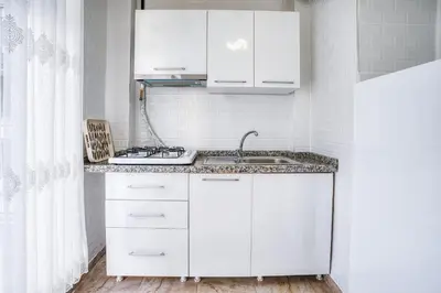 a kitchen with white cabinets and a sink at HANLAR Apart in Istanbul