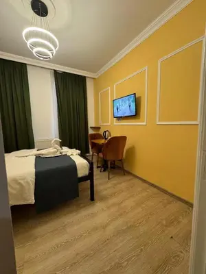 a bedroom with a bed and a table and a television at 24Suitetaksim in Istanbul