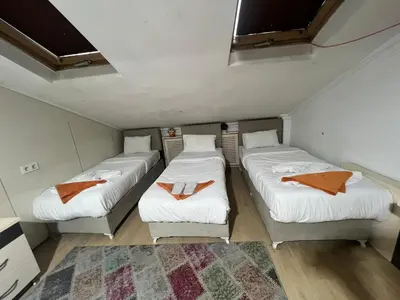three beds in a small room with a rug at Taksim Pera Premium Gold Hotel in Istanbul